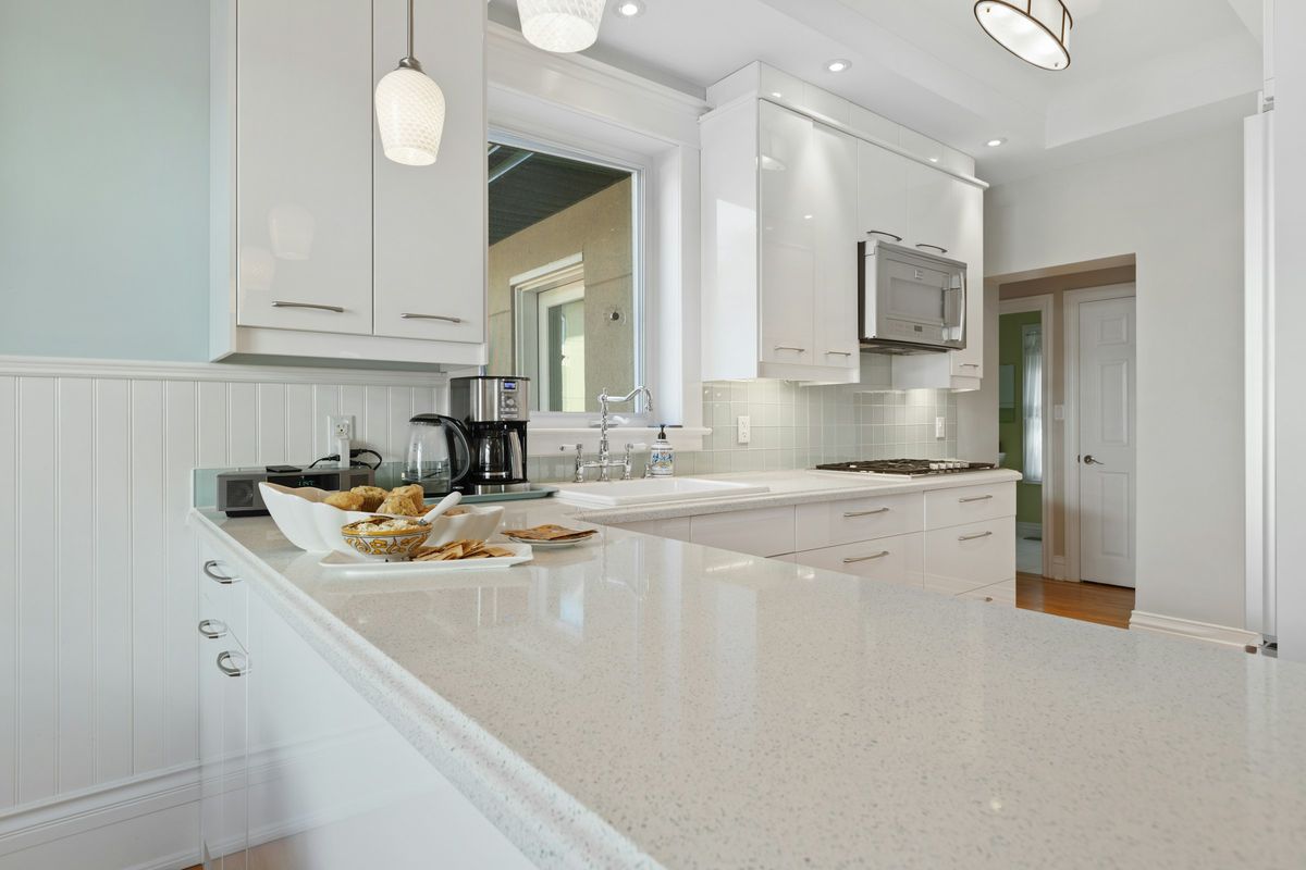 Sparkling white engineered-stone countertop with a rounded edge in a white kitchen
